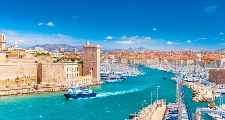 Leuchtendes Türkis erfüllt den Alten Hafen von Marseille mit einer Festung, einem Yachthafen und entfernten Bergen.