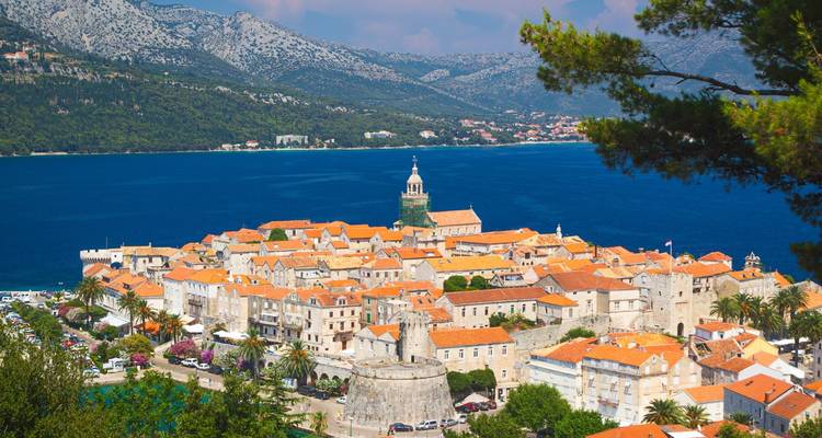 Die befestigte Halbinselstadt Korčula, umgeben von dem saphirfarbenen Meer unter rauen Bergen.