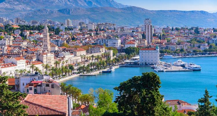 Vue panoramique de la Riva de Split, bordée de palmiers et de bâtiments historiques, face à la mer Adriatique.