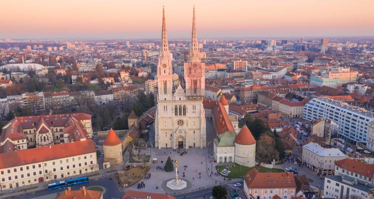 La lumière douce du coucher de soleil sur la cathédrale de Zagreb et les toits environnants depuis une vue en hauteur.