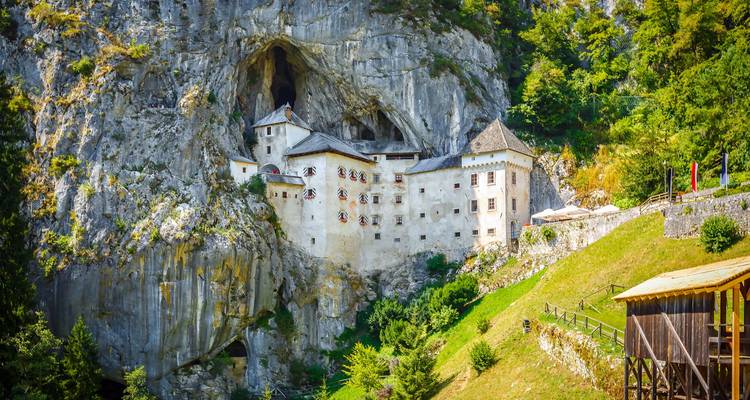 Le château de Predjama construit de manière spectaculaire dans une falaise surplombant les prairies verdoyantes près de Postojna.