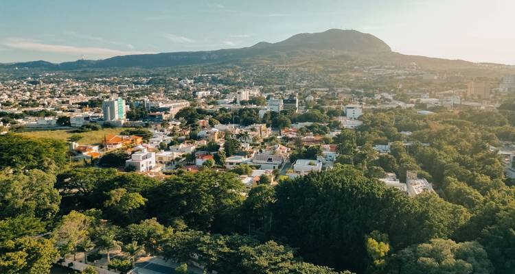 Vue aérienne ensoleillée d'une ville verdoyante située dans une vallée et entourée de montagnes basses, Tuxtla Gutiérrez.