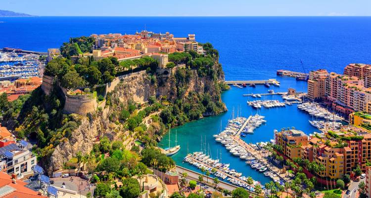 Vue aérienne spectaculaire du promontoire rocheux de Monaco surmonté de la vieille ville et entouré de ports remplis de yachts.