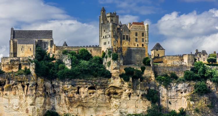 Mittelalterliche Steinburg, die dramatisch auf rauen Kalksteinfelsen vor einem bewölkten Himmel thront.