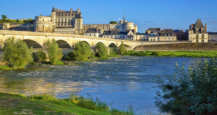 Schloss Amboise und gewölbte Brücke, die sich an einem sonnigen Tag im breiten Loiretal spiegeln.