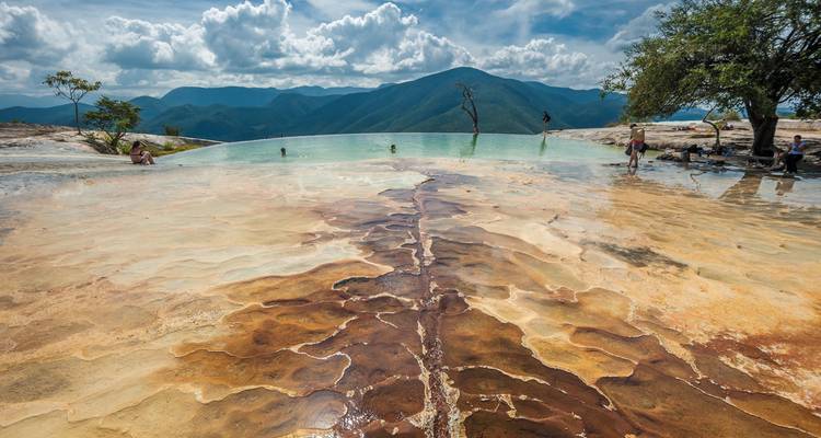 Piscine naturelle infinie d'Hierve el Agua surplombant des montagnes lointaines par une journée ensoleillée