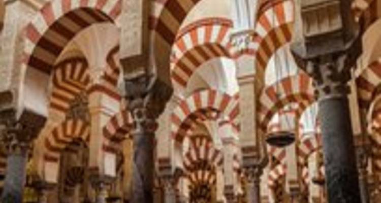 Imagen borrosa de arcos rojos y blancos rayados dentro de una histórica mezquita-catedral.