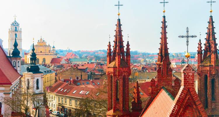 Vue panoramique sur la Vieille Ville de Vilnius avec ses flèches gothiques en briques rouges et une mer de toits en terre cuite.