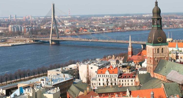 Vue aérienne de la Vieille Ville de Riga le long du fleuve Daugava avec le pont Vansu et les tours d'églises historiques en vue.