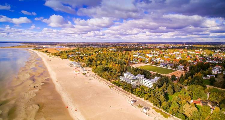 Vue aérienne de la longue plage de sable de Parnu, de la ville balnéaire et de la forêt environnante le long de la côte baltique.