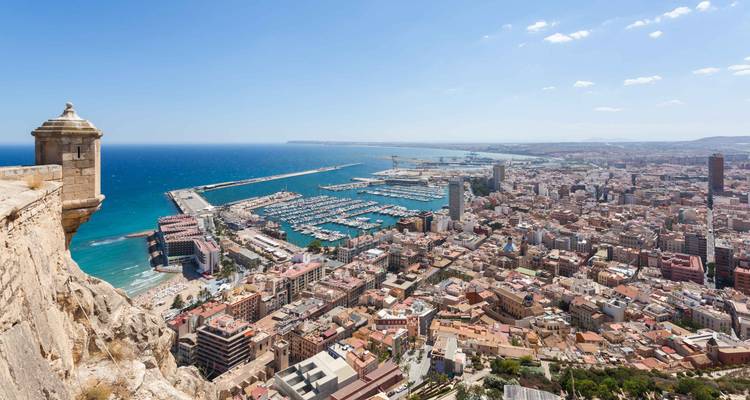 Ciudad costera expansiva y puerto deportivo vistos desde una fortification de acantilado alto.