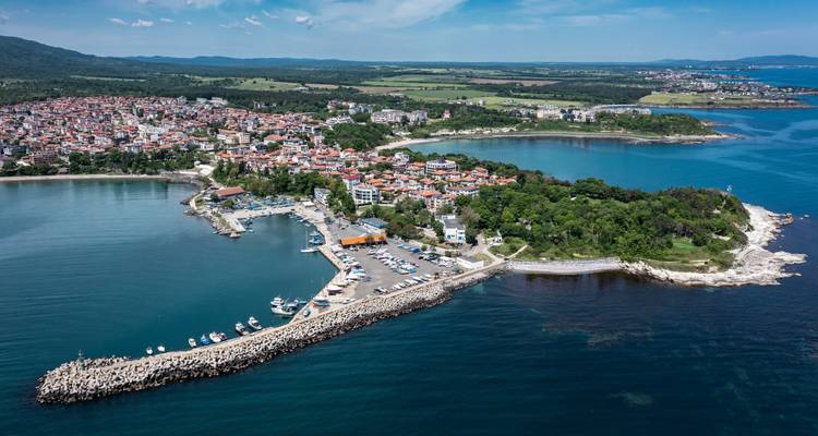 Panorama aérien d'une pittoresque ville péninsulaire balnéaire dotée de ports de plaisance et de baies bleues de part et d'autre.