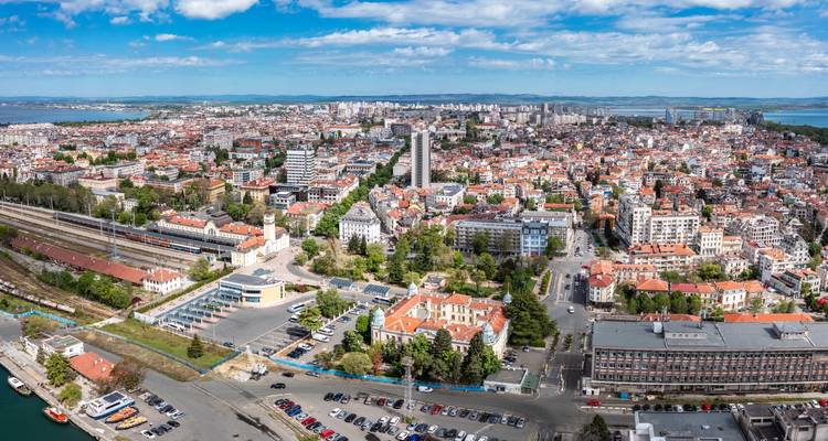 Vue panoramique aérienne de la ville de Burgas s'étendant jusqu'à la mer avec des lacs visibles à l'horizon.