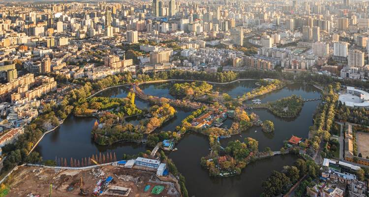 Panorama aérien de la ville de Kunming centrée autour du parc du Lac Vert avec une expansion urbaine dense au-delà.