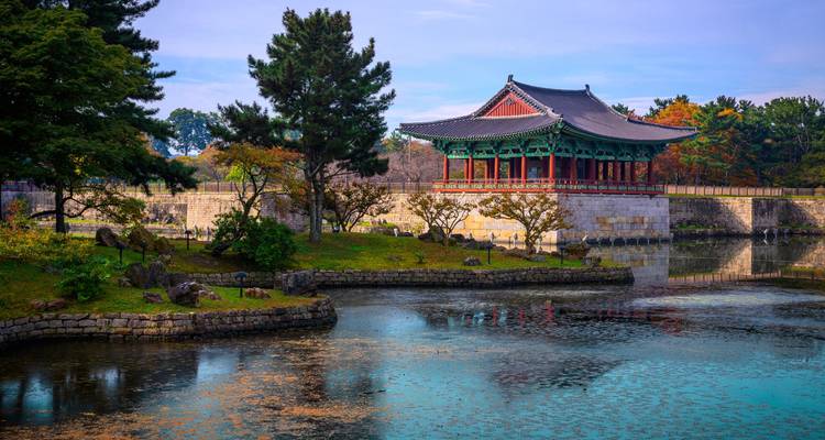 Le pavillon élégant repose sur des piliers au-dessus d'un étang tranquille sur le site d'Anapji à Gyeongju, entouré par le feuillage automnal.