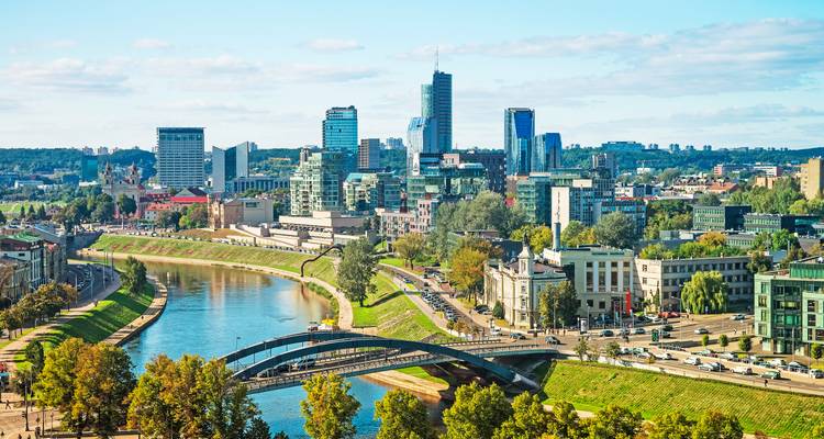 Moderner Skyline von Vilnius mit dem Fluss Neris und Brücken, umrahmt von Parks und Straßen.
