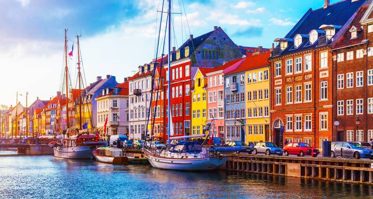 Les maisons de ville aux couleurs vives et les bateaux amarrés bordent le canal Nyhavn sous une lumière matinale cristalline.