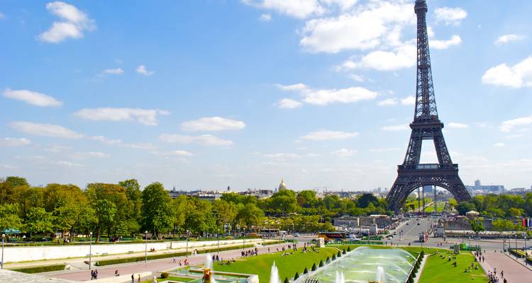 Vista desde los jardines de Trocadéro con fuentes que conducen hacia la Torre Eiffel en una tarde soleada.
