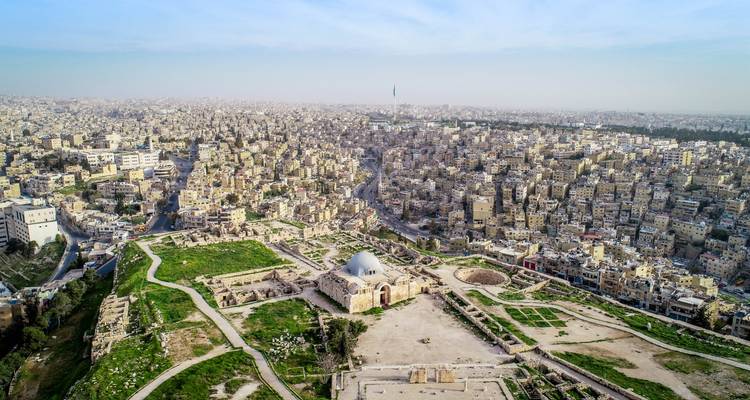 Vue aérienne des ruines de la Citadelle d'Amman et de l'étendue urbaine qui s'étend jusqu'à l'horizon.