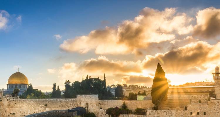 Sonnenstrahlen brechen durch Wolken über Jerusalems Felsendom und antiken Mauern.
