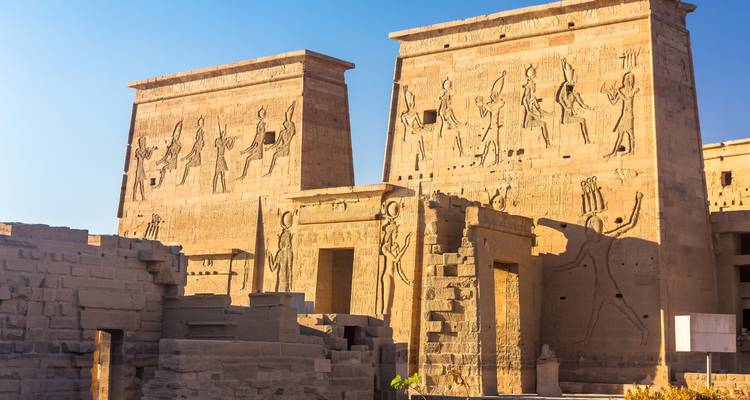 Pylônes recouverts de reliefs baignés de soleil du Temple de Philae aux tons chauds de grès