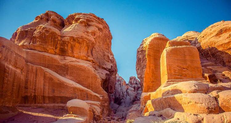 Gorge de grès baignée de soleil avec des parois rocheuses rouges imposantes à Pétra