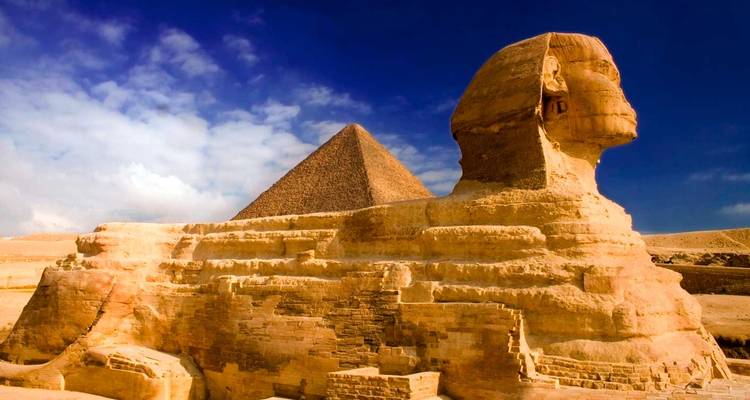 Die Große Sphinx mit der dahinter aufragenden Pyramide des Khafre vor einem tiefblauen Himmel