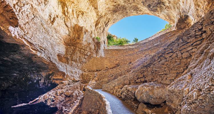 Stone path descending into the massive natural entrance of Carlsbad Caverns