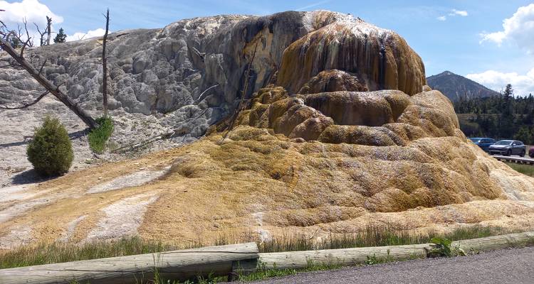 Zwiebel förmiger Travertinhügel mit geothermischen Mineralablagerungen und dampfendem Wasser, das herabrieselt.