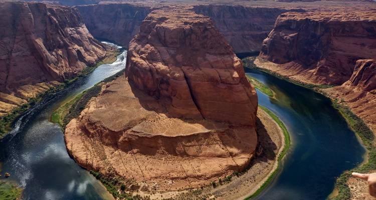 Die berühmte Horseshoe Bend mit smaragdgrünem Fluss, der eine aufragende Sandsteinmesa in spätem Nachmittagslicht umschlingt.