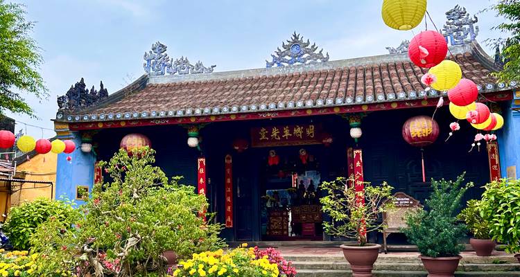 Bunte Laternen und Chrysanthemen in Töpfen schmücken den Eingang eines kleinen Tempels in Hoi An.