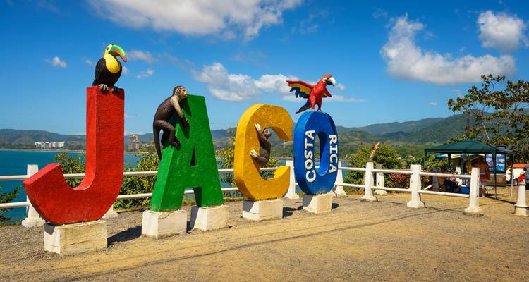 Letras de mirador coloridas de JACO Costa Rica decoradas con figuras de animales con vistas al océano.