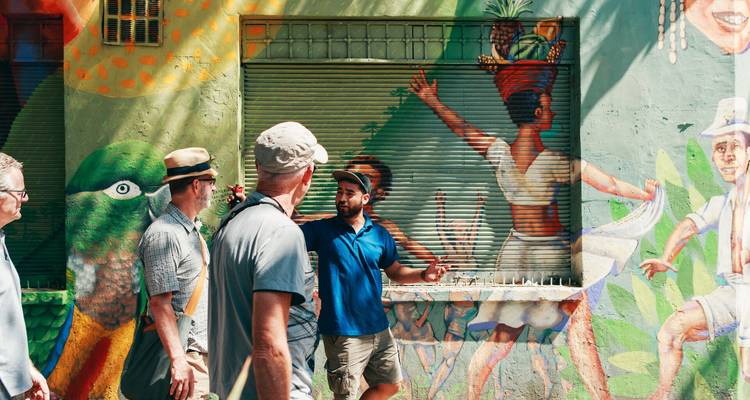 Un guía local explica el colorido arte callejero a los visitantes durante un paseo a pie.