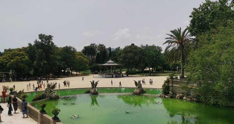 Grüner Teich und Skulpturen im Parc de la Ciutadella mit spazierenden Besuchern