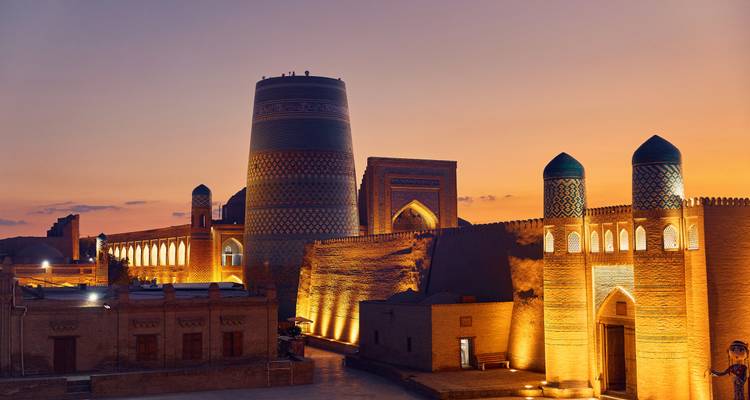 Khiva’s illuminated city walls and Kalta Minor minaret glow at sunset