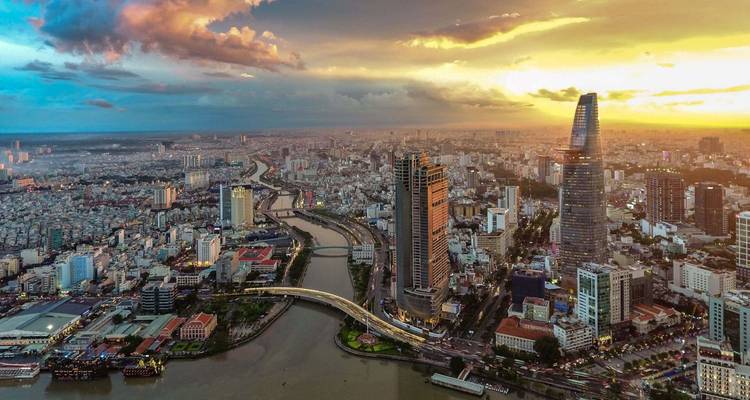Skyline von Ho-Chi-Minh-Stadt bei Sonnenuntergang mit dem Saigon-Fluss und leuchtenden Wolken