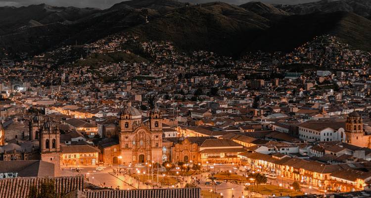 Nächtliche Luftaufnahme der Lichter von Cusco, eingebettet zwischen dunklen Bergkämmen