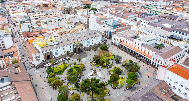 Vogelperspektive des historischen Plaza de la Independencia in Quito mit weißen Kolonialgebäuden, Kathedralenkuppeln und einem zentralen Garten