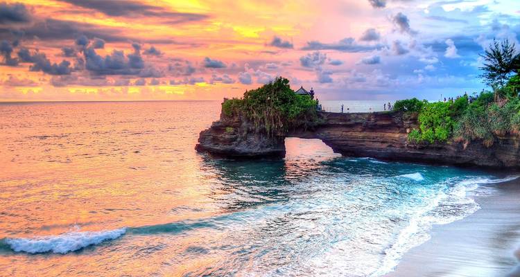 Couleurs de coucher de soleil brillant sur l'océan et arche rocheuse naturelle sur la côte de Tanah Lot à Bali.