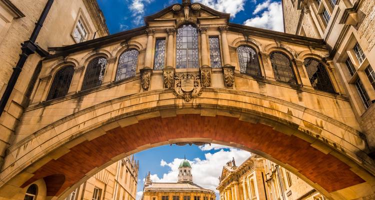 Vue ascendante du Pont des Soupirs d'Oxford enjambant une petite rue avec des bâtiments historiques en grès.