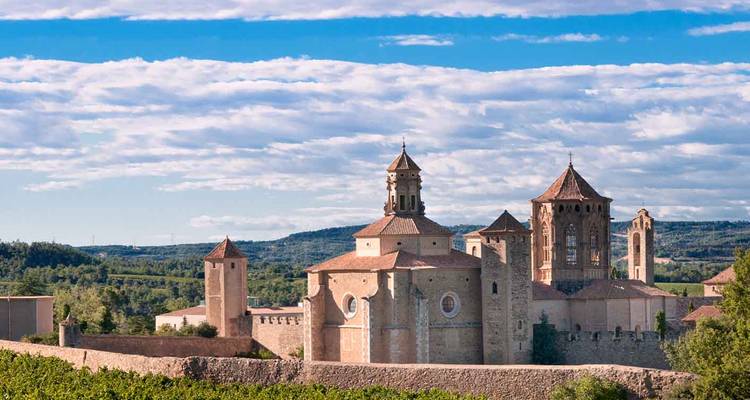 Rural backdrop of Poblet Monastery with stone towers and church amid rolling hills