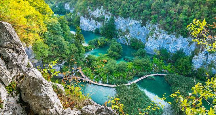 Lacs en terrasses turquoise et passerelles en bois nichés dans un canyon calcaire luxuriant