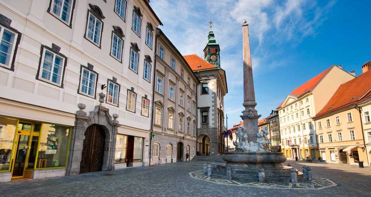 Place historique tranquille à Ljubljana avec tour de l'hôtel de ville baroque et fontaine obélisque en pierre