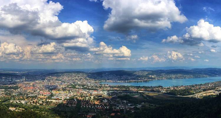 Vista panorámica amplia sobre la ciudad de Zurich y el lago de Zurich bajo nubes esponjosas dispersas