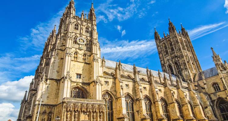 Les flèches gothiques et la façade élaborée de la cathédrale de Cantorbéry s'élèvent vivement contre un ciel bleu éclatant.
