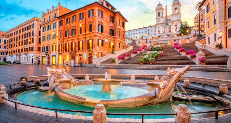 Vue du matin des Marches espagnoles de Rome et de la Fontaine de la Barcaccia ornées de fleurs éclatantes et de lumière chaleureuse.