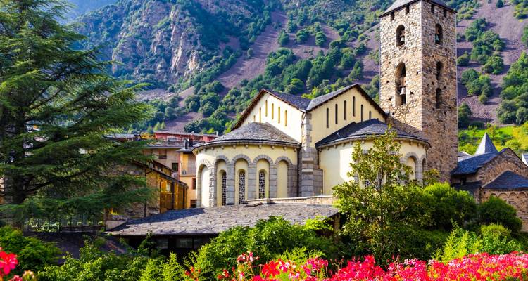 Stenen kerk en toren verscholen tussen weelderige bergen in Andorra onder het ochtendlicht