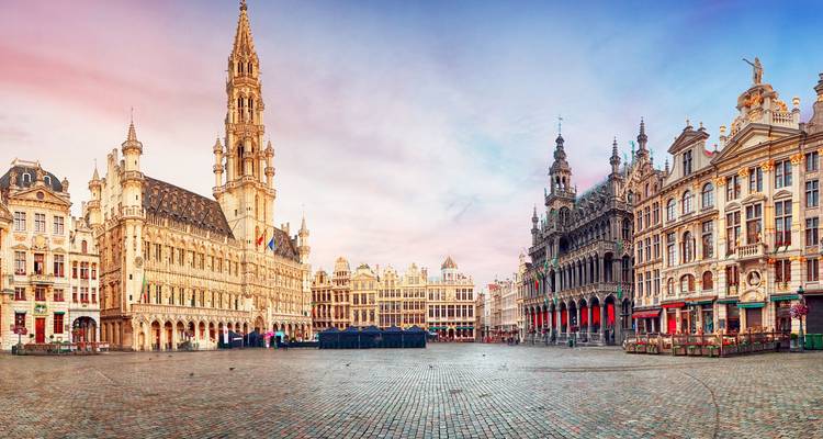 Panoramisch uitzicht op het Brusselse Grote Markt bij zonsopgang met pastelkleurige lucht en lege kasseien