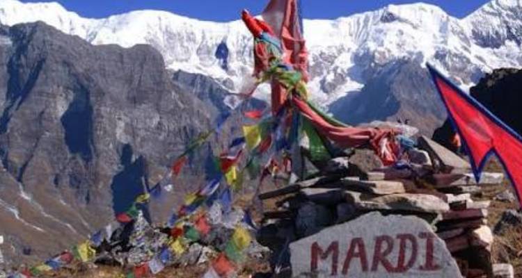Cairn avec drapeaux de prière et pierre peinte portant l'inscription « MARDI » en arrière-plan de la chaîne enneigée de l'Annapurna
