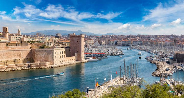 Aussicht über Marseilles Alten Hafen mit dem Fort Saint-Jean und hunderten von Segelbooten, die den Yachthafen unter einem strahlend blauen Himmel säumen.